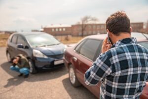 A driver involved in a car accident makes a call to the police.